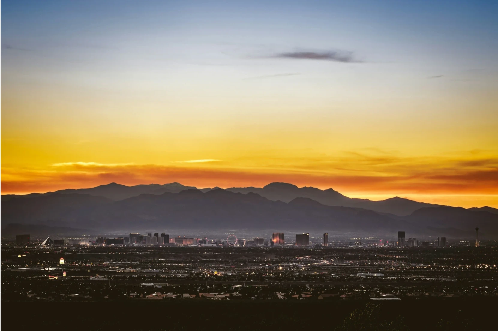 The Las Vegas skyline at sunset, with the mountains of Southern Nevada behind it